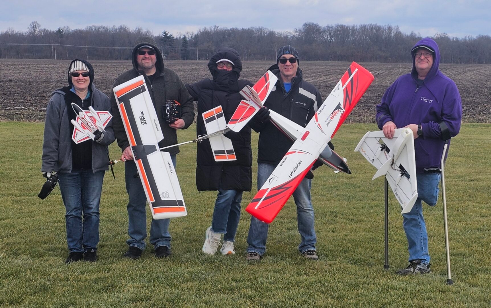 RC pilots holding foam airplanes at the flying field after a winter flying session