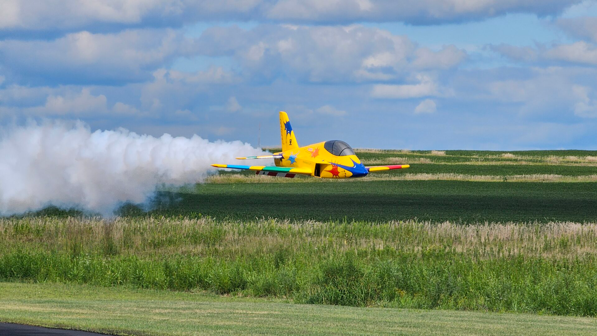 Yellow RC turbine jet flying with a smoke system