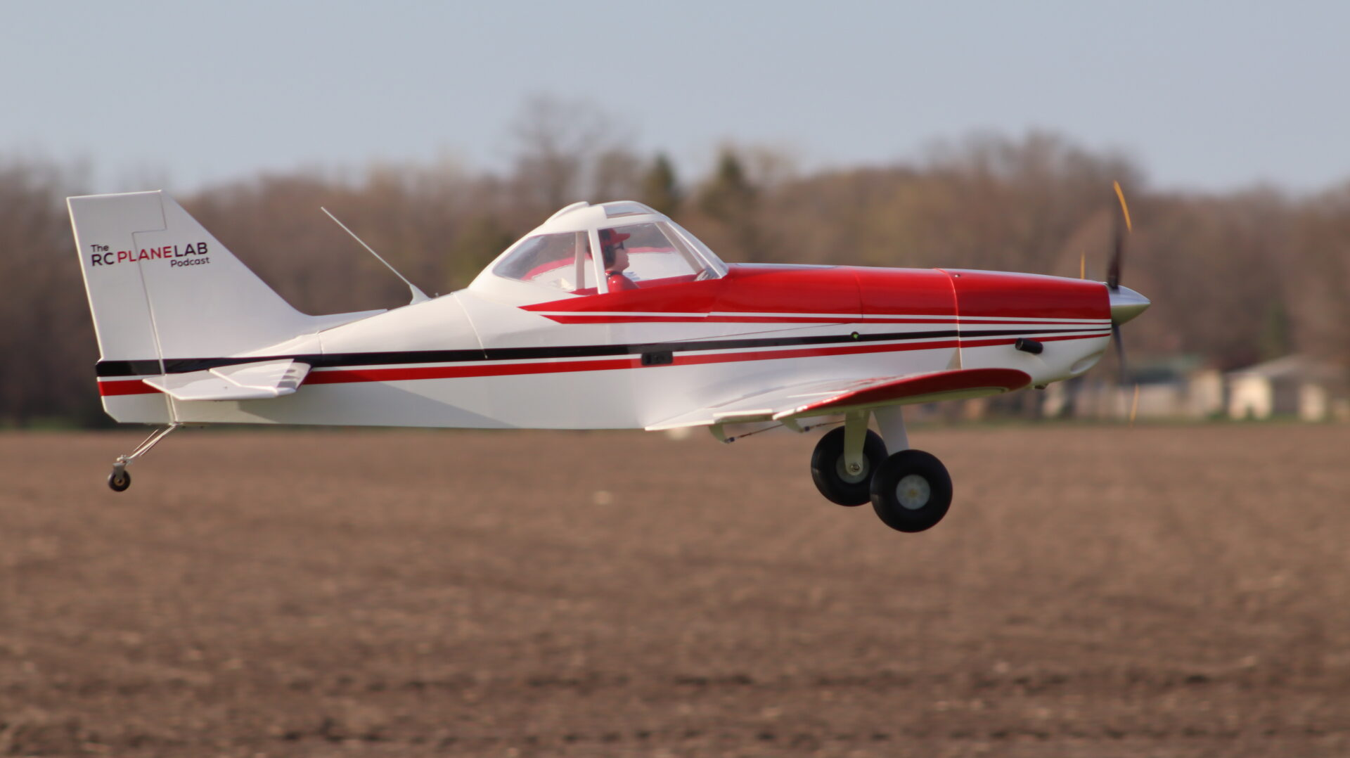 Red and white RC airplane on landing approach at the flying field